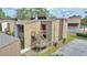 Inviting multi-level townhome featuring exterior staircase with red door and views of the community's tennis courts at 5316 Burning Tree Dr # A09-2, Orlando, FL 32811
