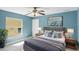 Comfortable bedroom featuring light blue walls, a ceiling fan, and a large screen TV at 5524 Loma Vista, Davenport, FL 33896