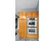 Eat in kitchen with stainless double oven and light wood cabinets with crown molding at 5524 Loma Vista, Davenport, FL 33896