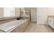 Bathroom showcases a large soaking tub with tiled surround and glass enclosed shower at 581 Pebble Beach Dr, Davenport, FL 33896