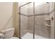 Tiled shower with glass door and integrated shower caddy at 581 Pebble Beach Dr, Davenport, FL 33896