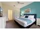 Bedroom features king bed with blue accent wall, ceiling fan, and access to attached bathroom at 581 Pebble Beach Dr, Davenport, FL 33896