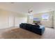 Cozy bonus room with neutral walls, carpet flooring, and a comfortable blue sofa, perfect for relaxing at 581 Pebble Beach Dr, Davenport, FL 33896