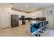 Modern kitchen featuring white cabinets, stainless steel appliances, a breakfast bar, and a stylish backsplash at 581 Pebble Beach Dr, Davenport, FL 33896