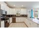 Bright kitchen featuring white cabinets, stainless steel appliances, and dark backsplash at 581 Pebble Beach Dr, Davenport, FL 33896