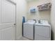Convenient laundry room with modern washer, dryer, and storage shelves at 581 Pebble Beach Dr, Davenport, FL 33896