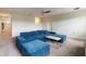 Cozy living room offering a blue sectional sofa and a modern coffee table on carpet flooring at 581 Pebble Beach Dr, Davenport, FL 33896