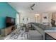 Bright living room with a teal accent wall, neutral furnishings, and an open layout with ample natural light at 581 Pebble Beach Dr, Davenport, FL 33896