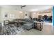 Open-concept living room features neutral walls, tile floors, contemporary decor, and a large gray sectional sofa at 581 Pebble Beach Dr, Davenport, FL 33896
