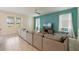 Spacious living room with a sectional sofa, large windows, and neutral color palette at 581 Pebble Beach Dr, Davenport, FL 33896