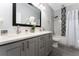 Well-lit bathroom featuring a double sink vanity, marble-look shower, and modern fixtures at 7629 Marietta St, Orlando, FL 32807