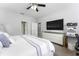 Bedroom showcasing a ceiling fan, gray accent pillows, and a television on a white cabinet at 7629 Marietta St, Orlando, FL 32807