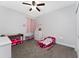 Comfortable bedroom with plush carpeting, toys, and a ceiling fan at 7629 Marietta St, Orlando, FL 32807