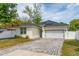 Inviting single-story home boasts a light-colored facade, solar panels, and a brick paver driveway at 7629 Marietta St, Orlando, FL 32807