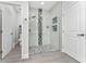 Elegant walk-in shower with glass door and a black-and-white tiled accent wall at 7629 Marietta St, Orlando, FL 32807