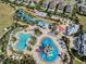 Aerial view of a resort with large pools, water slides, splash pad, community green space, and beautiful homes at 7665 Fairfax Dr, Kissimmee, FL 34747