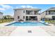 A backyard featuring a pool, spa, patio, lounge chairs and fenced yard of this bright home at 7665 Fairfax Dr, Kissimmee, FL 34747
