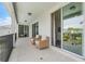 Spacious balcony with wicker chairs and view of lush landscaping, perfect for outdoor enjoyment at 7665 Fairfax Dr, Kissimmee, FL 34747