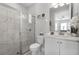 Bathroom with a glass shower, a white vanity, and a decorative mirror at 7665 Fairfax Dr, Kissimmee, FL 34747