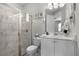 Bathroom with a glass shower, a white vanity, and a decorative mirror at 7665 Fairfax Dr, Kissimmee, FL 34747