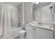 Well-lit bathroom featuring marble tiling, a shower-tub combo, and a vanity with ample countertop space at 7665 Fairfax Dr, Kissimmee, FL 34747
