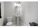 Powder room with pedestal sink, toilet, and neutral decor at 7665 Fairfax Dr, Kissimmee, FL 34747