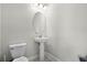 A half-bath featuring a pedestal sink, oval mirror, and tiled floors at 7665 Fairfax Dr, Kissimmee, FL 34747