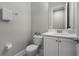 A half-bath featuring a white vanity with quartz countertops at 7665 Fairfax Dr, Kissimmee, FL 34747