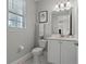 Powder room with a decorative mirror and a window letting in natural light at 7665 Fairfax Dr, Kissimmee, FL 34747
