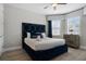 Bedroom featuring a luxe, plush blue headboard, wood flooring, and a ceiling fan at 7665 Fairfax Dr, Kissimmee, FL 34747