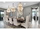 Bright dining room with chandelier lighting and a long wooden table perfect for entertaining at 7665 Fairfax Dr, Kissimmee, FL 34747