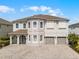 Stunning two-story home with a three-car garage and a beautifully paved driveway and a stone facade at 7665 Fairfax Dr, Kissimmee, FL 34747