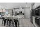Modern kitchen with stainless steel appliances, quartz countertops, large island, and stylish black bar stools at 7665 Fairfax Dr, Kissimmee, FL 34747