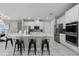 Modern kitchen with stainless steel appliances, quartz countertops, large island, and stylish black bar stools at 7665 Fairfax Dr, Kissimmee, FL 34747