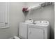 Functional laundry room equipped with a washer, dryer, and shelving for organized storage at 7665 Fairfax Dr, Kissimmee, FL 34747