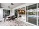 A covered patio featuring an outdoor dining set and sliding glass doors that lead to the living area at 7665 Fairfax Dr, Kissimmee, FL 34747