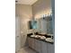 A well-lit bathroom showcases a double sink vanity with a large mirror and updated fixtures, plus a walk-in shower at 8074 Santee Dr, Kissimmee, FL 34747