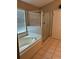 Bathroom showcasing a luxurious soaking tub next to a separate glass-enclosed shower, designed for relaxation and convenience at 8074 Santee Dr, Kissimmee, FL 34747