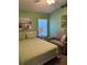 Green bedroom featuring a comfortable bed, cozy chair, and a bright window at 8074 Santee Dr, Kissimmee, FL 34747