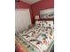 A vibrant bedroom features a double bed with a colorful tropical themed quilt and a flamingo pattern at 8074 Santee Dr, Kissimmee, FL 34747