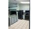 Open-concept kitchen with stainless steel appliances, gray cabinets, and tile flooring at 8074 Santee Dr, Kissimmee, FL 34747