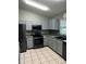 Modern kitchen equipped with stainless steel appliances, sleek grey cabinetry, and tiled backsplash at 8074 Santee Dr, Kissimmee, FL 34747