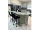 Kitchen area featuring an extended breakfast bar seating, gray cabinetry, and modern appliances at 8074 Santee Dr, Kissimmee, FL 34747
