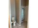 Powder room featuring a toilet, a tiled floor, an exit and other doors, creating a functional and private space at 8074 Santee Dr, Kissimmee, FL 34747