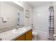 Cozy bathroom featuring a single vanity, toilet, and shower-tub combo with a patterned curtain and tiled walls at 814 Bloomingdale Dr, Davenport, FL 33897