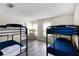 Spacious bedroom featuring two bunk beds with blue bedding, hardwood-style floors, and natural light at 814 Bloomingdale Dr, Davenport, FL 33897