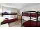 Bright bedroom showcasing two sets of bunk beds with hardwood-style flooring and a dresser with a TV at 814 Bloomingdale Dr, Davenport, FL 33897