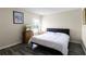 Bedroom with neutral walls, dark blue headboard, TV on a dresser and wood floors at 814 Bloomingdale Dr, Davenport, FL 33897