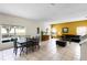 Open-concept living room with tile floors, large windows, and comfortable seating arrangement facing the backyard at 814 Bloomingdale Dr, Davenport, FL 33897