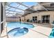 The screened-in pool area features a relaxing spa, grill, and cozy lounge seating at 814 Bloomingdale Dr, Davenport, FL 33897